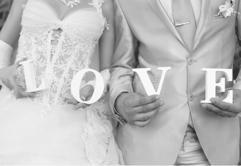 bride and groom holding letters that spell "love"