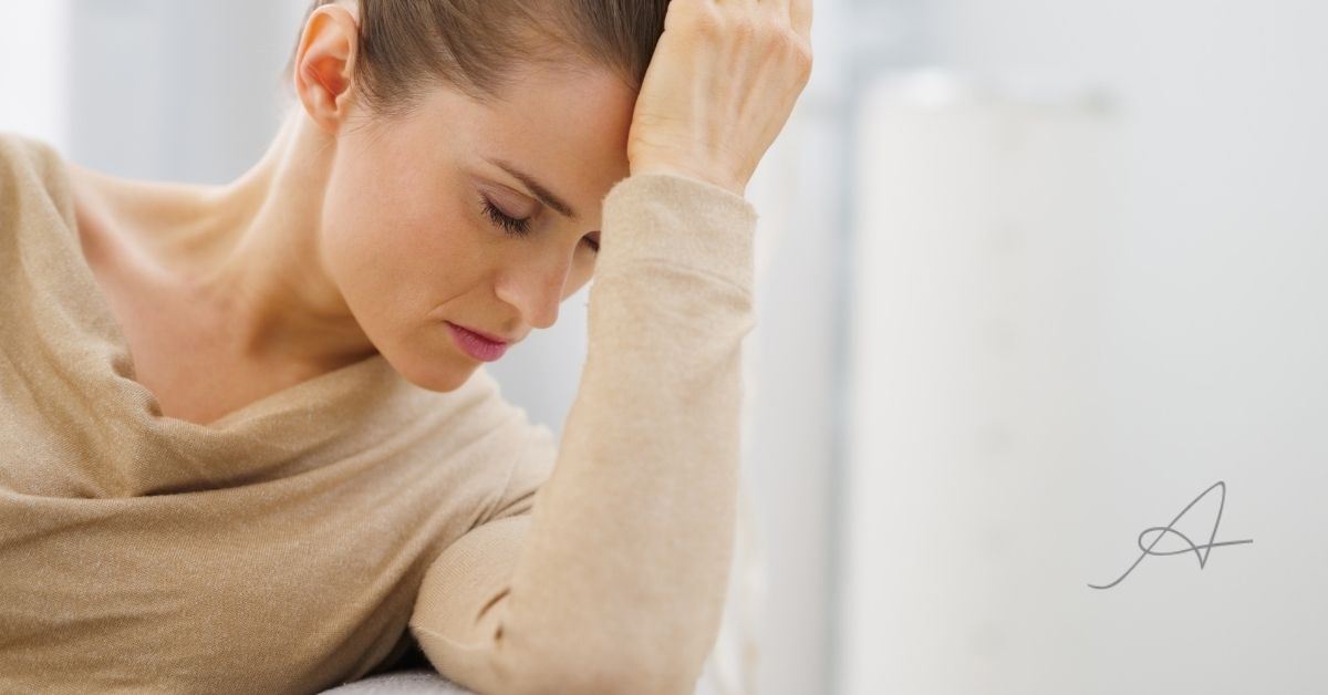 Woman with head on hand.