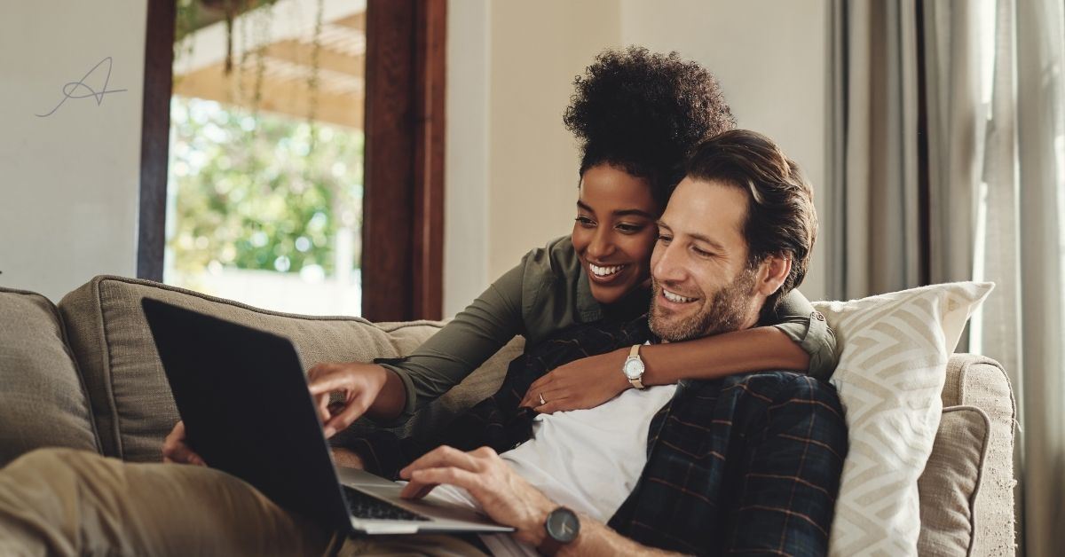 Woman and man on the computer smiling.