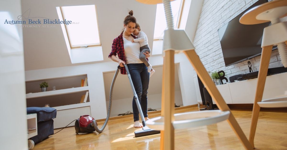 Woman holding child and cleaning.