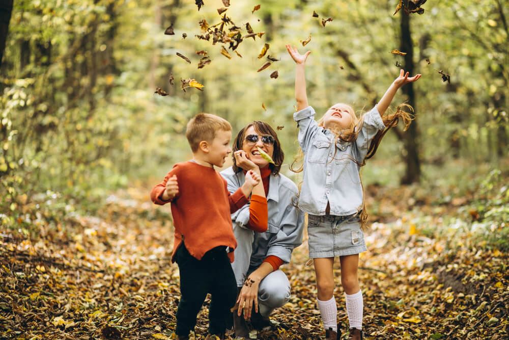 Mother with her little son and daughter in an autumn park.
